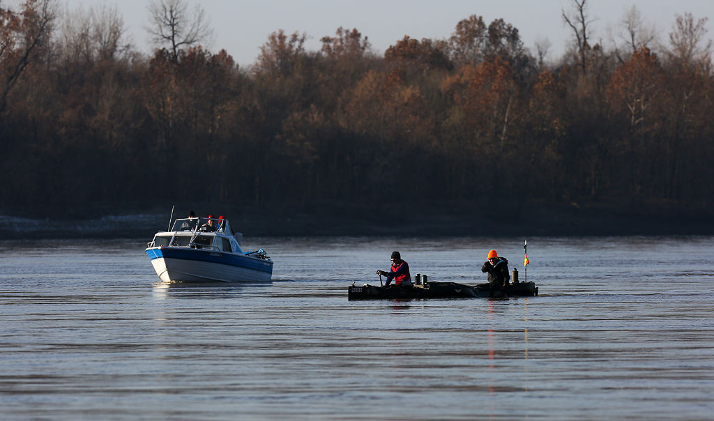 Steve Landick and Jeremy Vore paddle their boat down the Missouri River in Hermann